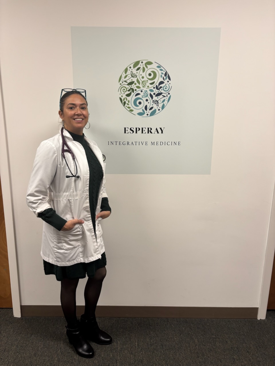 Clinician beside the Esperay Integrative Medicine sign